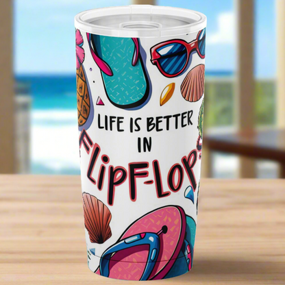 a white tumbler with seashells, sunglasses and flip flops and the text life is better in flip flops