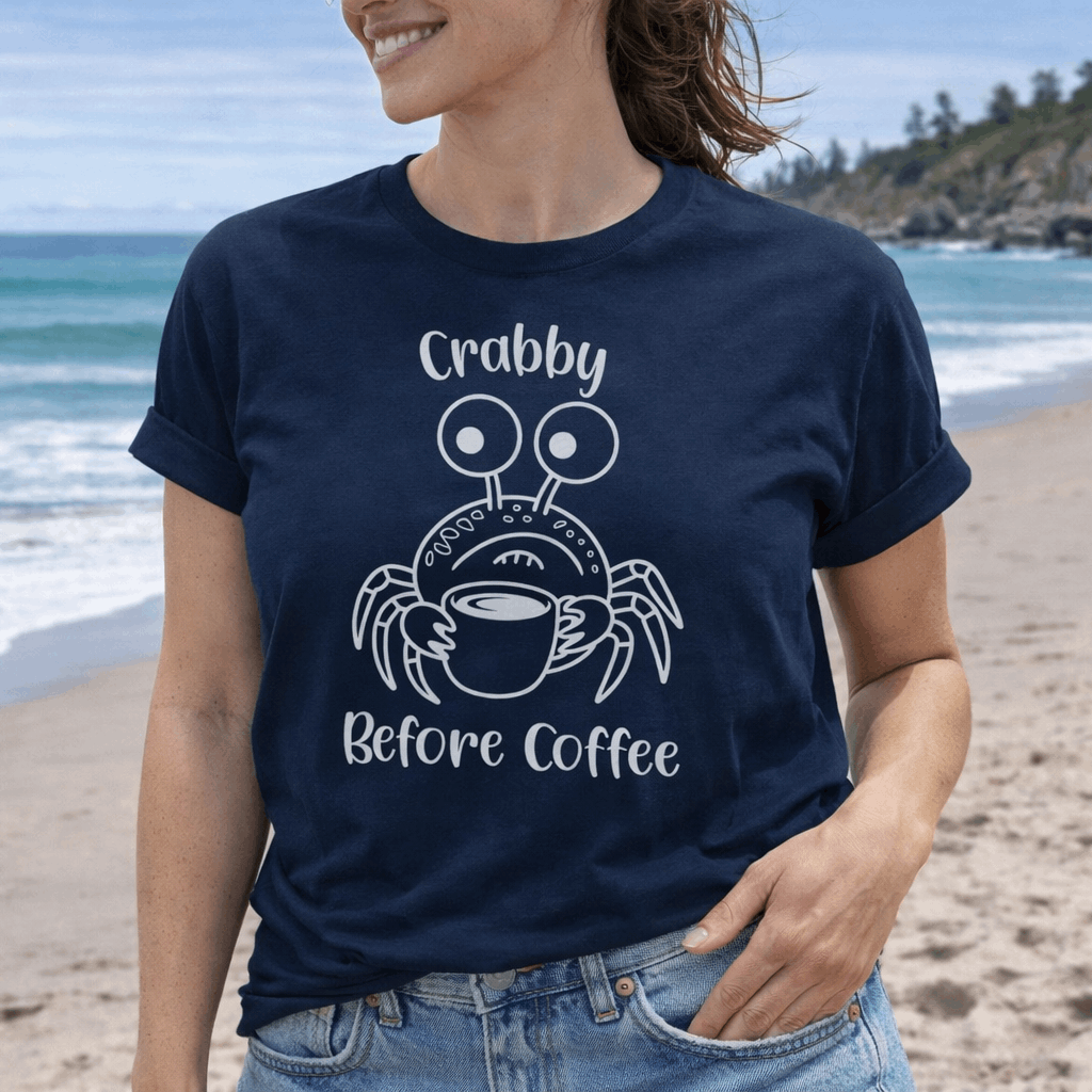 Woman wearing a navy t-shirt with a crab graphic and 'Crabby Before Coffee' text