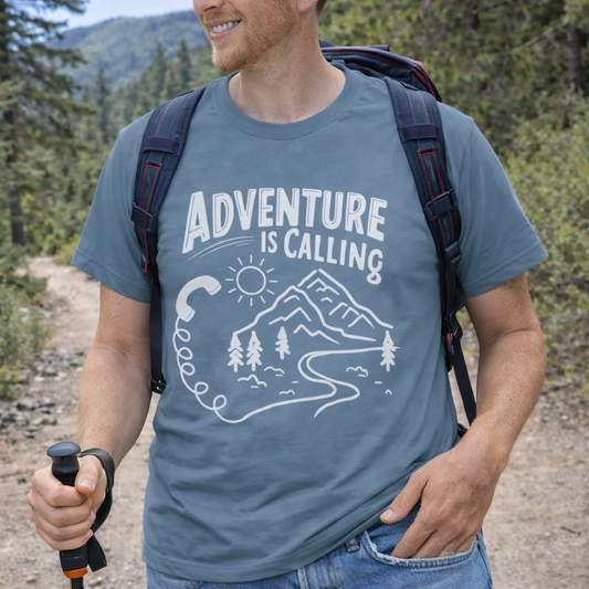 Man hiking in a forest wearing a t-shirt with 'Adventure is Calling' text and graphic.