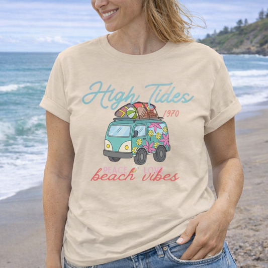Woman wearing a t-shirt with a graphic design of a van and text on a beach.