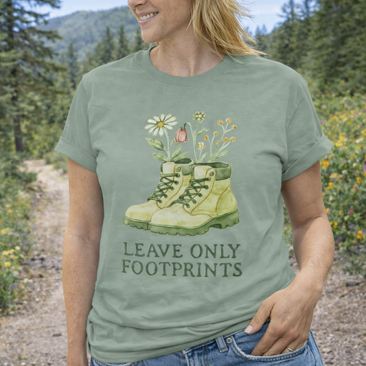 Person wearing a green t-shirt with a nature-themed design and 'Leave Only Footprints' text in a forest setting.