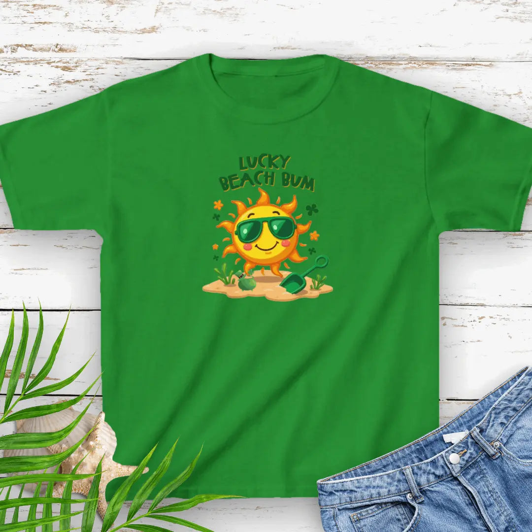 Lucky Beach Bum Child's Green small T-shirt with a smiling sun wearing green sunglasses on the beach with beach toys.