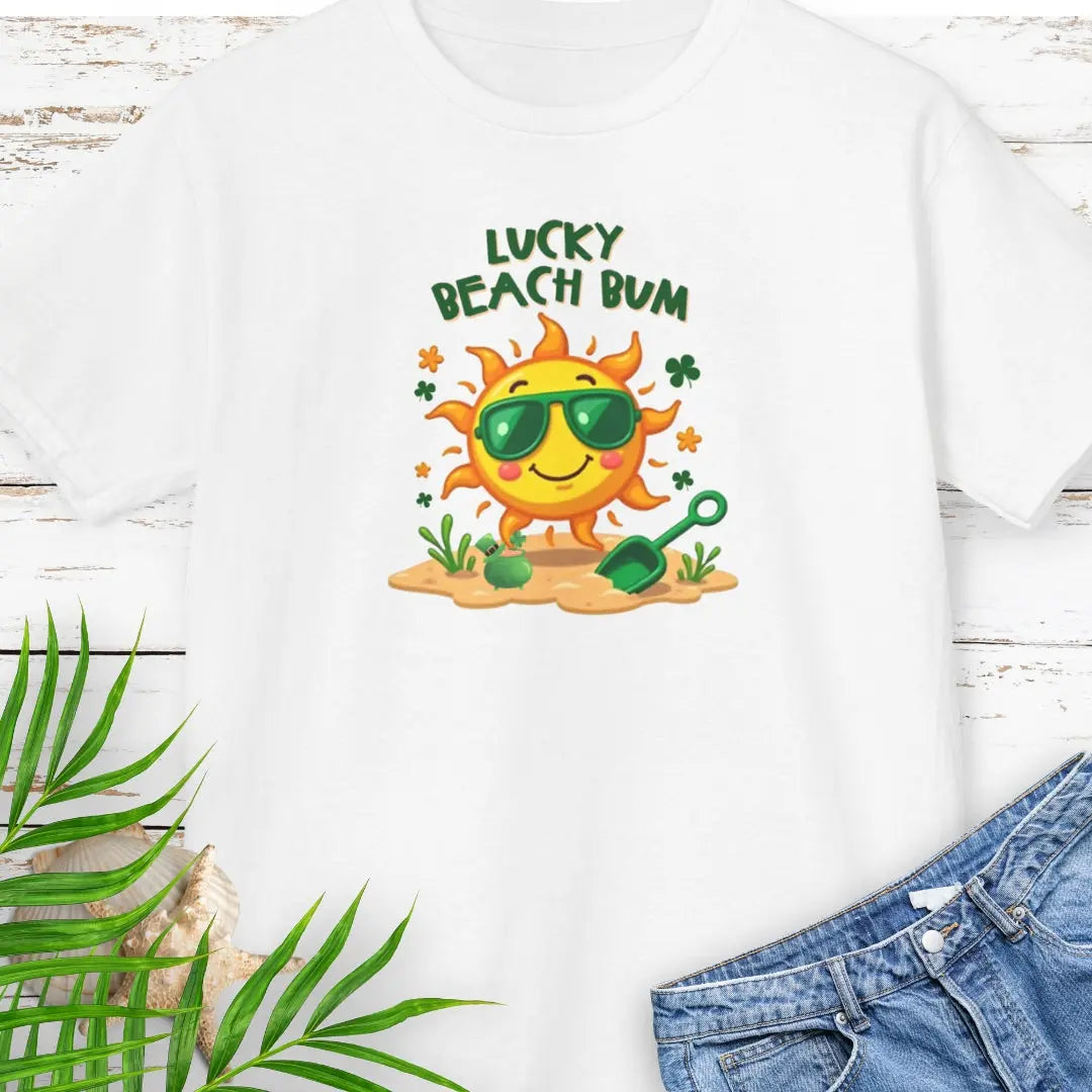 Lucky Beach Bum Child's White T-shirt with a smiling sun wearing green sunglasses on the beach with beach toys.
