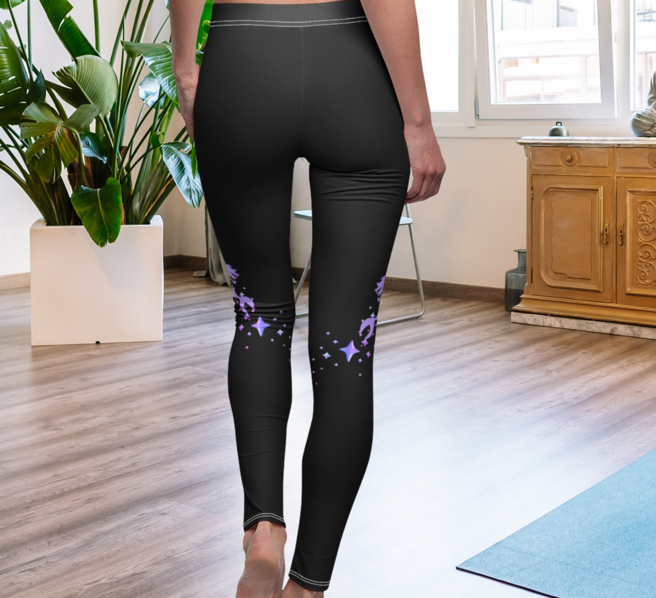 Back view of black leggings with a purple mermaid and stars coming up the side at knee height.