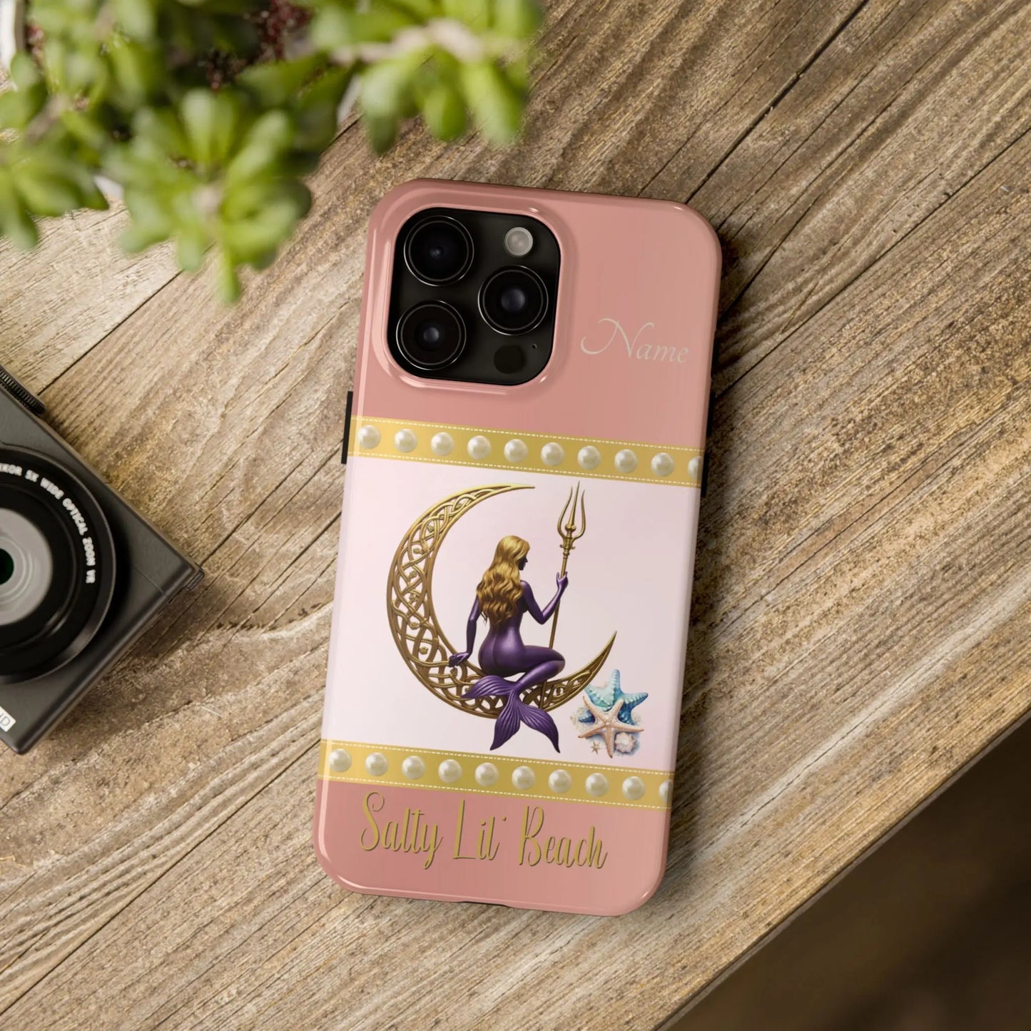 Pink and White 15 Pro Max iPhone Case with mermaid sitting on a celtic crescent moon holding a trident that says Salty Lil' Beach. Personalized with name.
