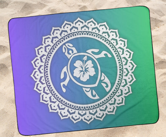 Beach blanket with mandala sea turtle on purple and green gradient background.