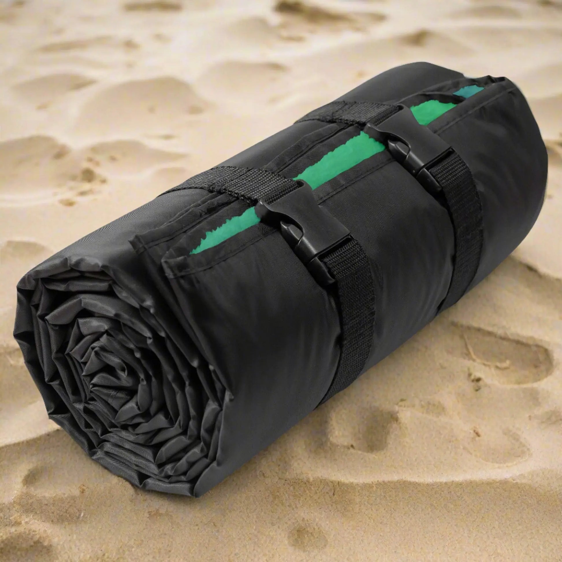 Rolled up and buckled beach blanket showing the waterproof black backing.