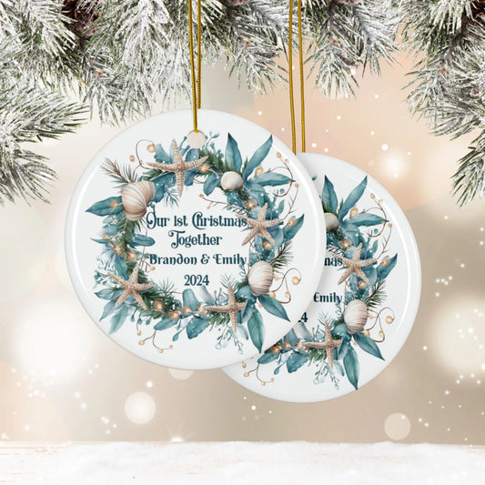 Front and back white round ornament featuring a beach-themed wreath with seashells and starfish, displaying "Our 1st Christmas Together." Personalized with names and year, this coastal holiday keepsake is perfect for celebrating a special first Christmas.