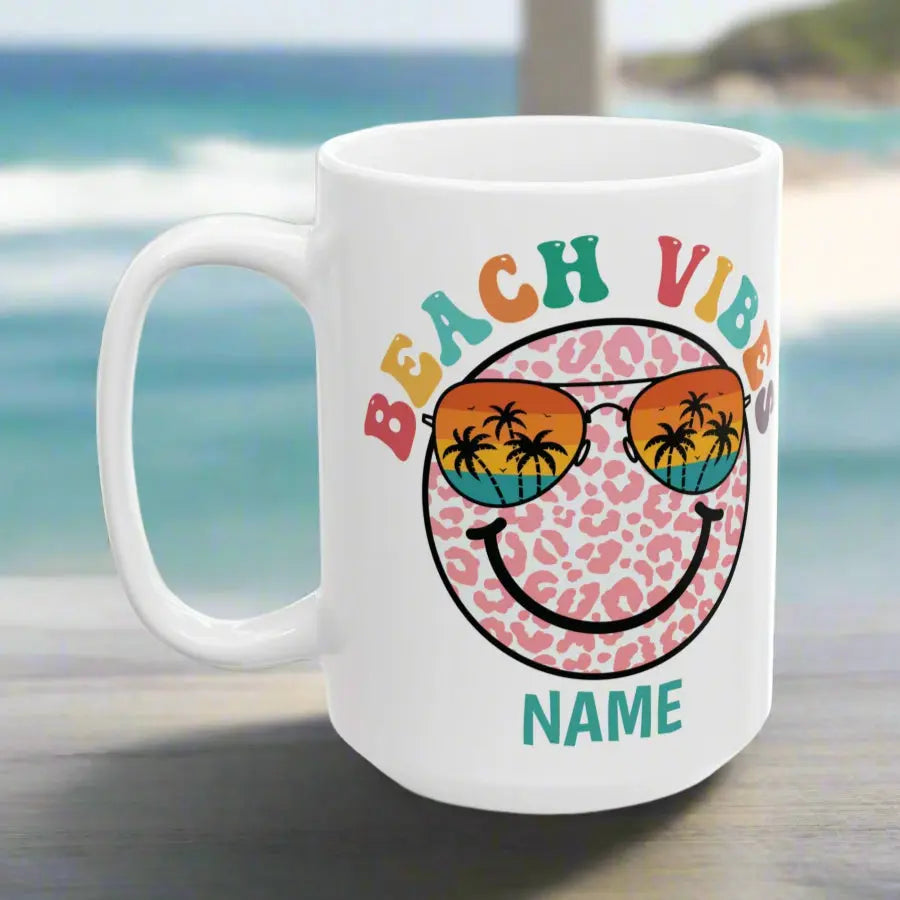 White 15 oz ceramic mug with "Beach Vibes" colorful text, featuring a retro smiley face wearing sunset sunglasses with palm trees. Personalized with a name, this coastal-themed coffee mug is perfect for beach lovers and summer vibes.