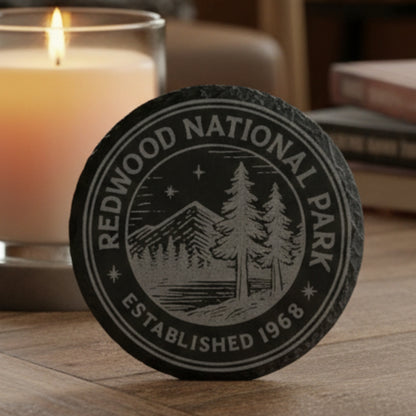 Black 4" round engraved slate coaster with Redwood National Park patch with scenic design and text.