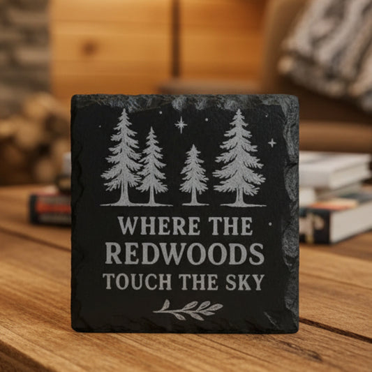 Black slate coaster with engraved trees and text Where the Redwoods Touch the Sky.