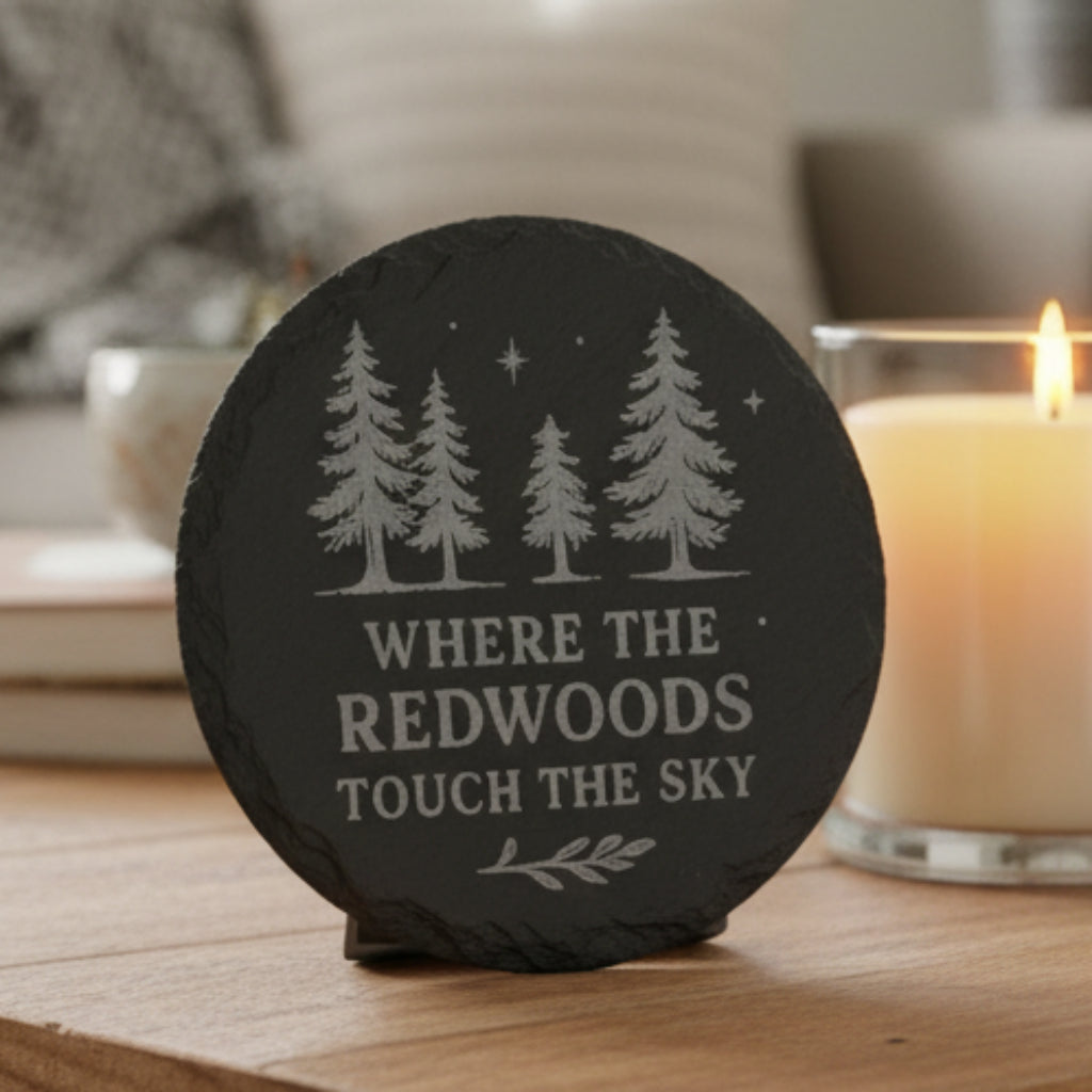 Black slate stone with engraved trees and text Where the Redwoods Touch the Sky.