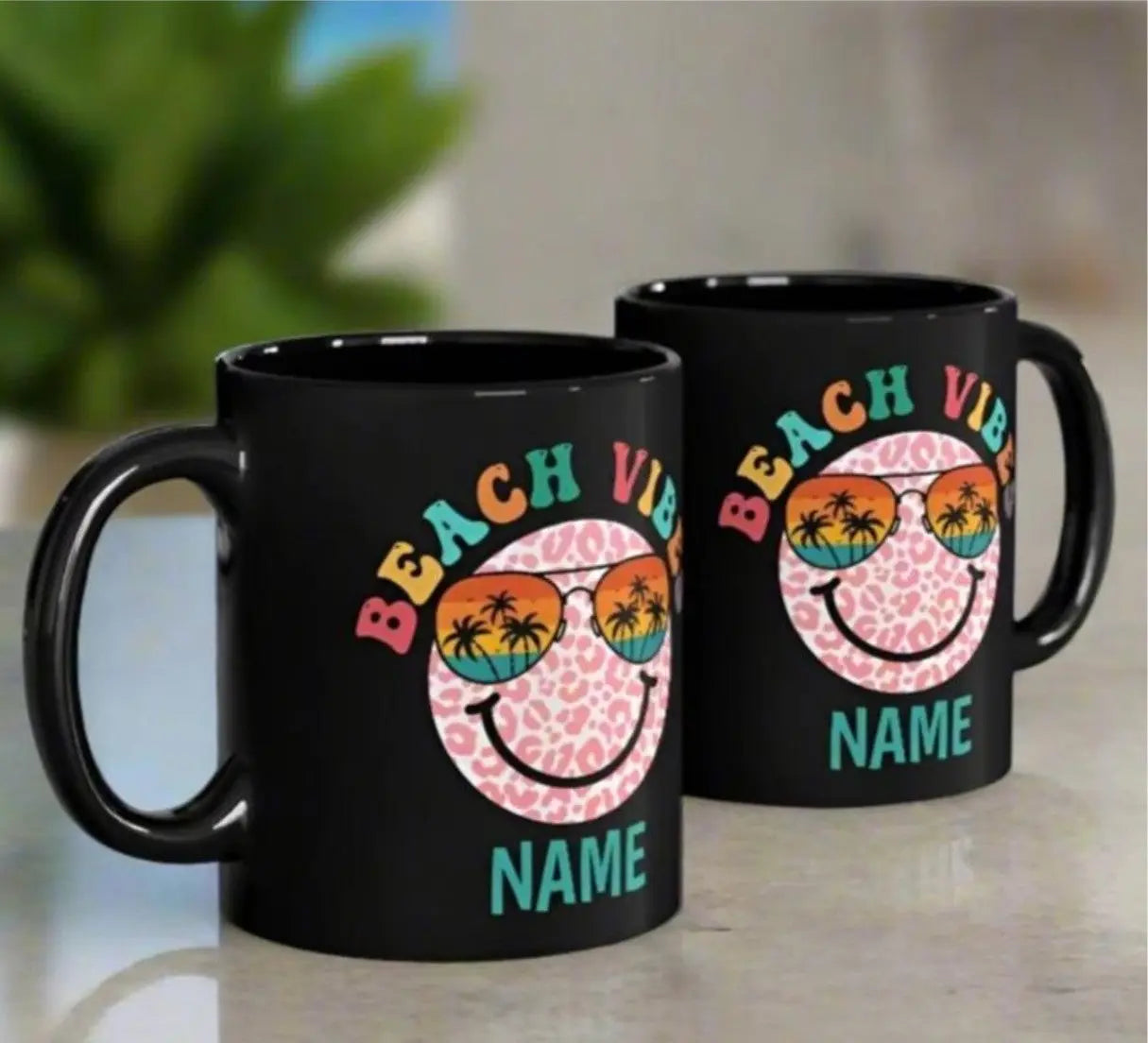 Two Black 11 oz ceramic mug with "Beach Vibes" colorful text, featuring a retro smiley face wearing sunset sunglasses with palm trees. Personalized with a name, this coastal-themed coffee mug is perfect for beach lovers and summer vibes.