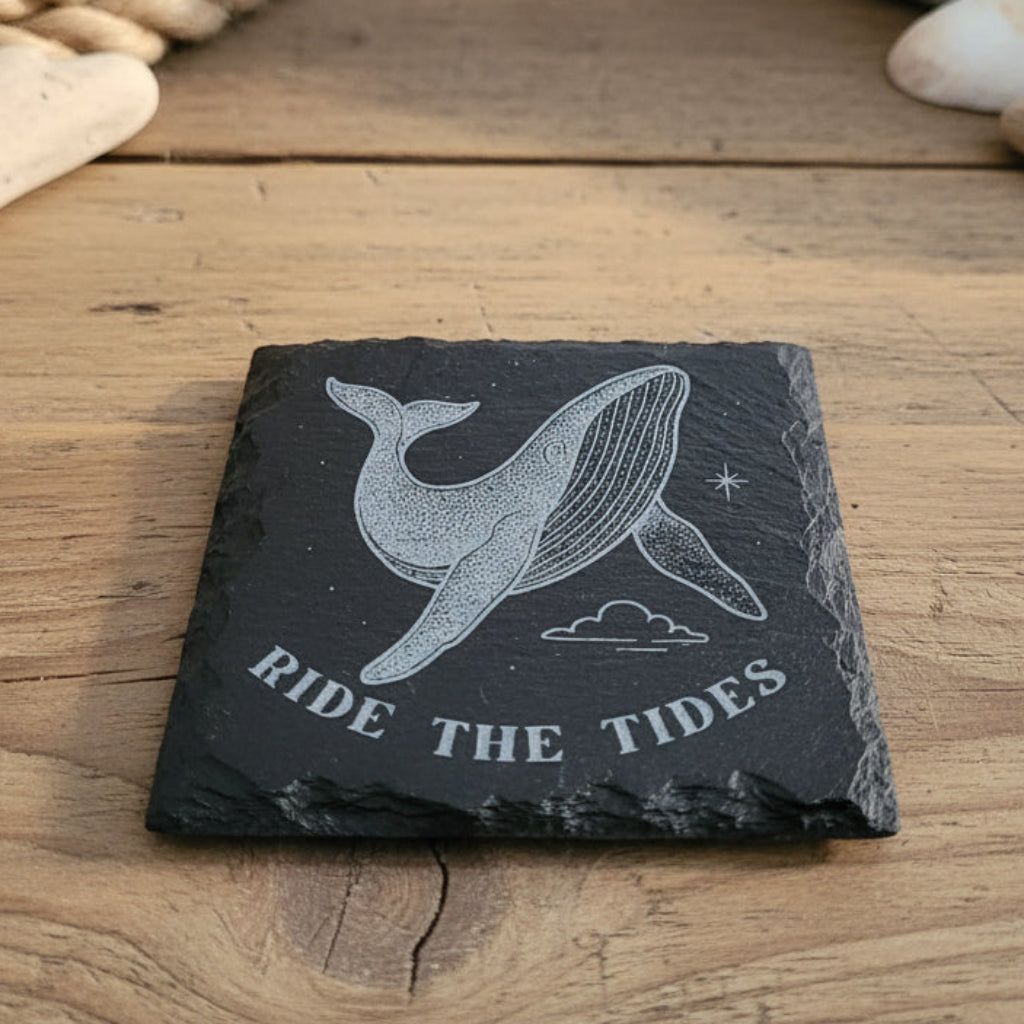 Black slate coaster with whale design and 'Ride the Tides' text engraved.