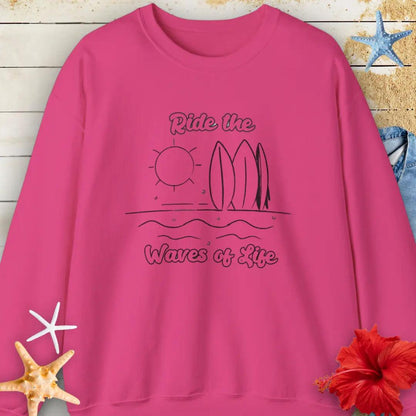 Our Ride the Waves of Life Sweatshirt  in Heliconia with Surfboards and the sun line art with the phrase ide the Waves of Life. Perfect for any surfing enthusiast.