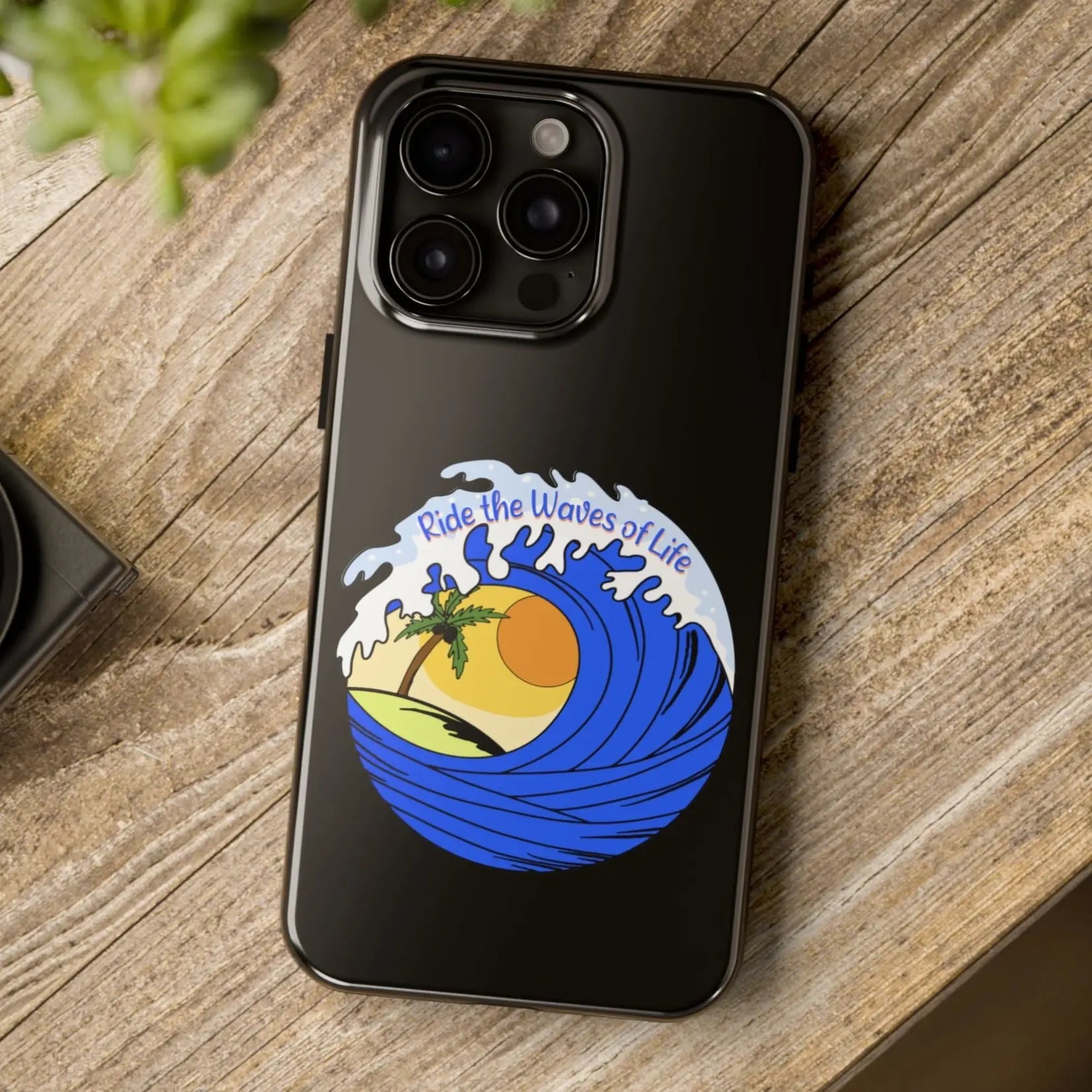 Black iPhone 15 Pro Max Case with wave with sun and palm tree in the middle that says Ride the Waves of Life.