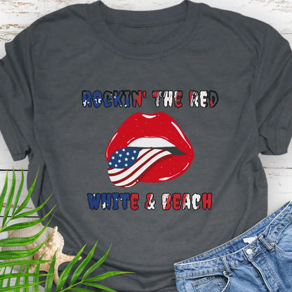 Dark Heather T-shirt with rolling stones lips with American flag tongue hanging out that says Rockin' the Red, White & Beach with text that is filled with the flag.