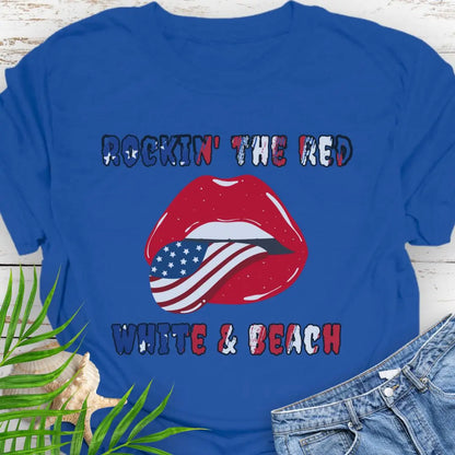 Royal Blue T-shirt with rolling stones lips with American flag tongue hanging out that says Rockin' the Red, White & Beach with text that is filled with the flag.