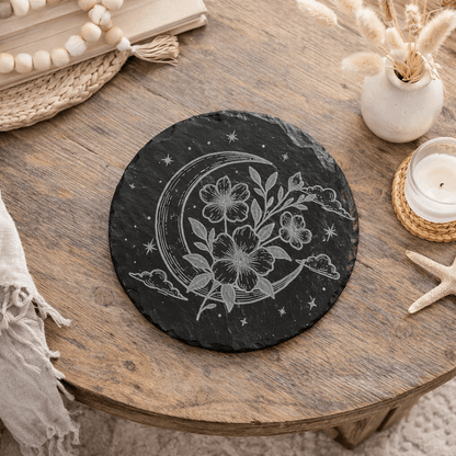 Decorative black slate coaster with floral and moon design.