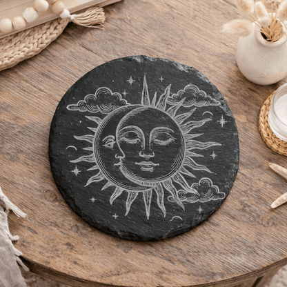 Decorative slate coaster with sun and moon design.