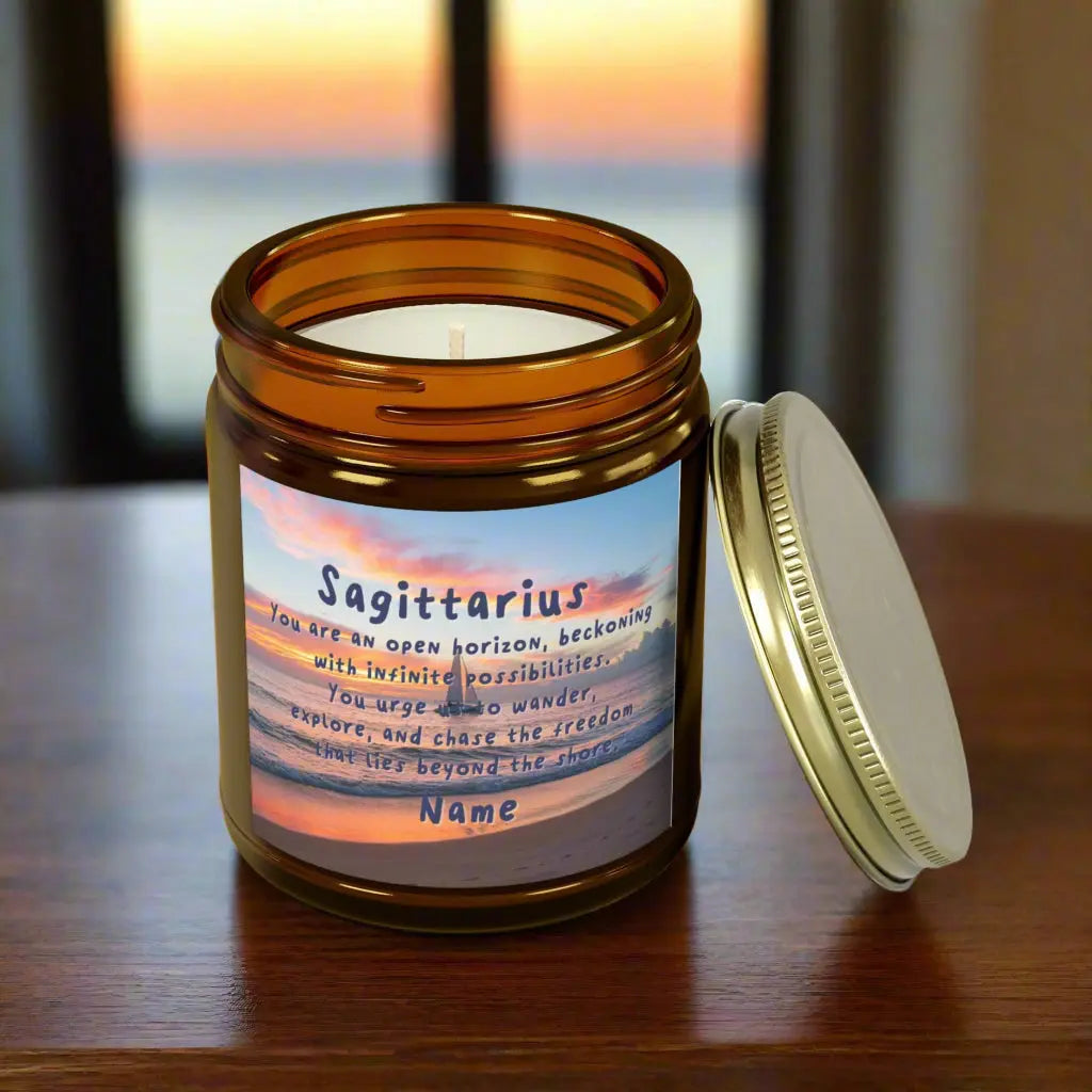 Elegant Sagittarius Zodiac hand-poured coconut apricot wax scented candle in a 9 oz amber glass jar with gold lid, featuring a picture of the ocean at sunset with a sailboat in the distance and an inspirational quote personalized. A beach-inspired astrology gift, perfect for relaxation and decor.