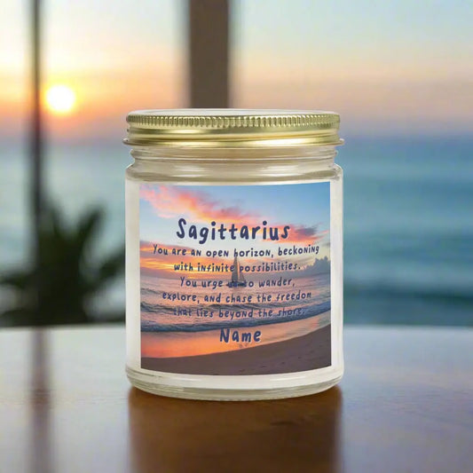 Elegant Sagittarius Zodiac hand-poured coconut apricot wax scented candle in a 9 oz clear glass jar with gold lid, featuring a picture of the ocean at sunset with a sailboat in the distance and an inspirational quote personalized. A beach-inspired astrology gift, perfect for relaxation and decor.