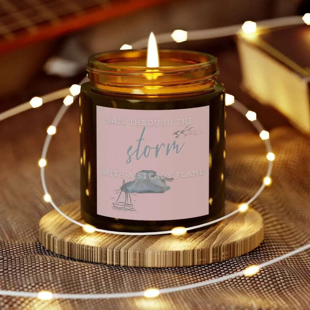 4 oz Amber Jar candle featuring label with a sailboat design and the inspirational phrase 'Sail Through the Storm with a Steady Flame,' making it the perfect addition to any nautical or coastal-themed home decor.