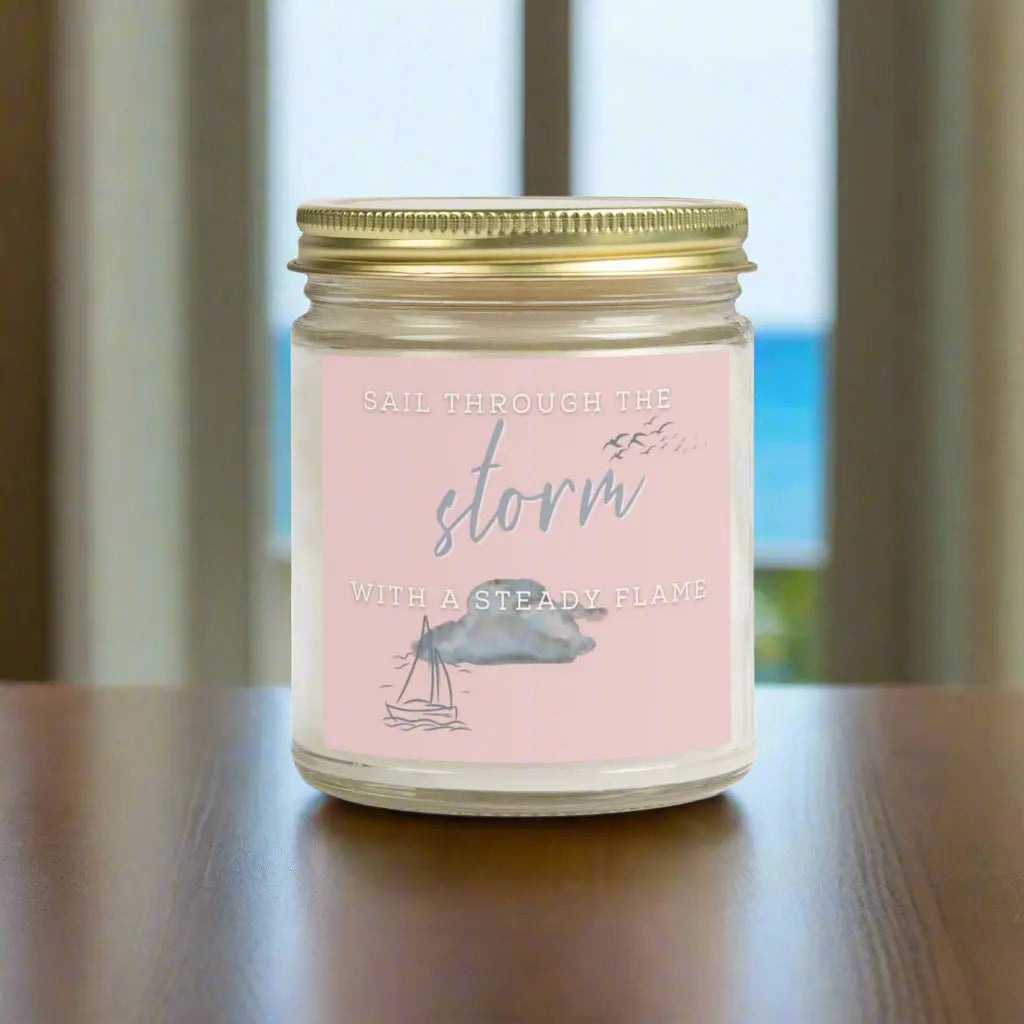 9 oz Scented Clear Jar candle featuring label with a sailboat design and the inspirational phrase 'Sail Through the Storm with a Steady Flame,' making it the perfect addition to any nautical or coastal-themed home decor.