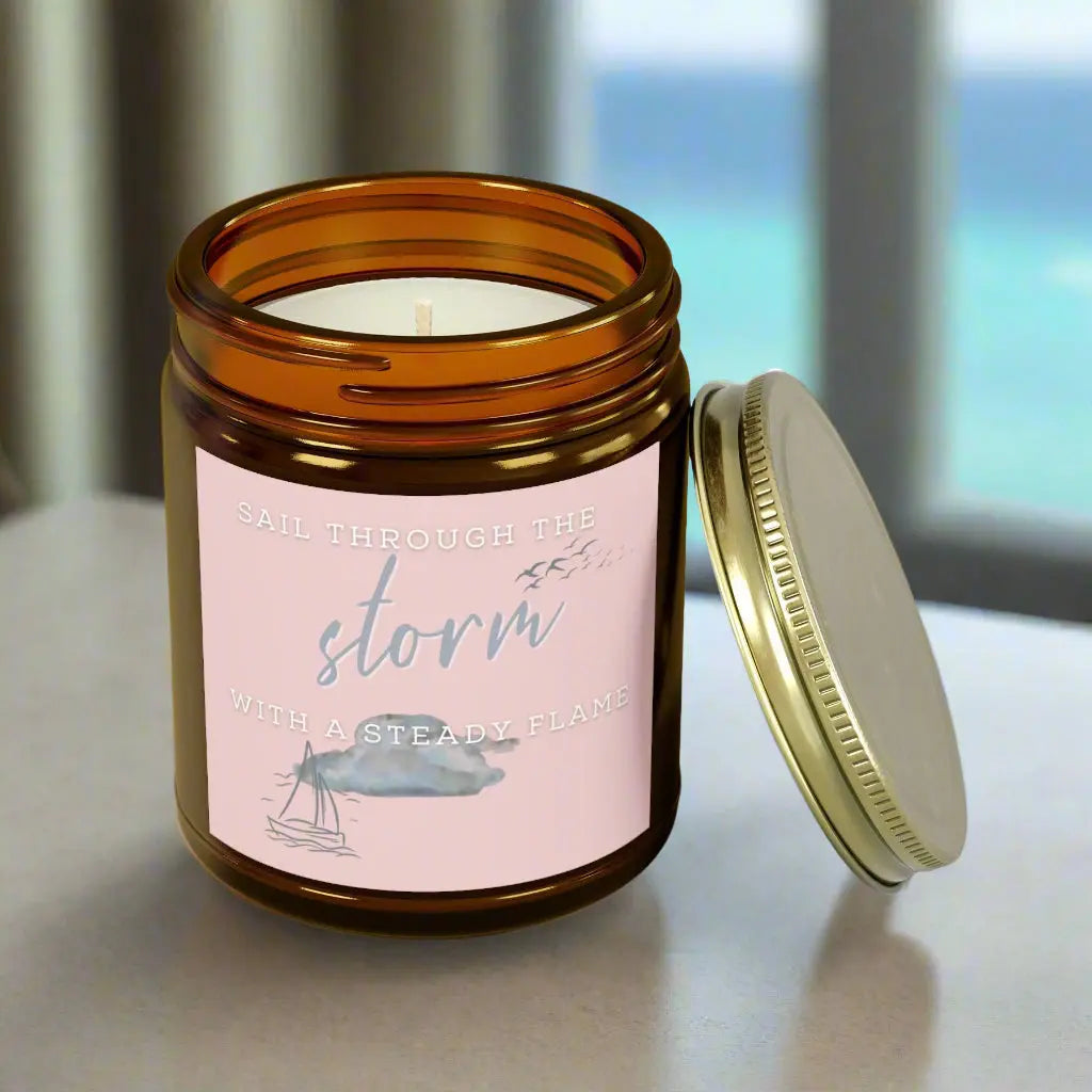 9 oz Scented Amber Jar candle featuring label with a sailboat design and the inspirational phrase 'Sail Through the Storm with a Steady Flame,' making it the perfect addition to any nautical or coastal-themed home decor.