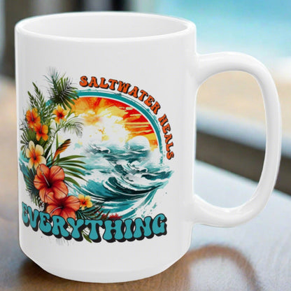 White ceramic mug that says Saltwater Heals Everything around ocean waves with tropical flowers