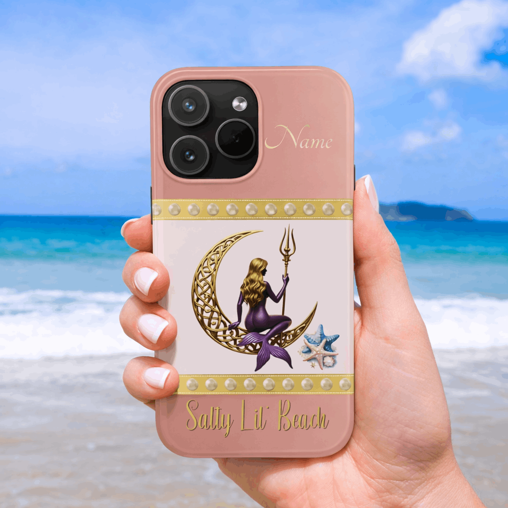Phone case with mermaid design held by a hand on a beach
