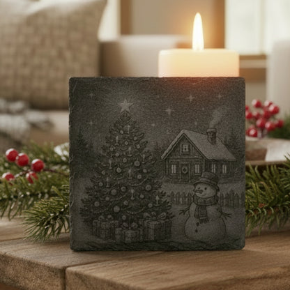 Decorative slate coaster engraved with a snowy Christmas scene featuring a tree and snowman.