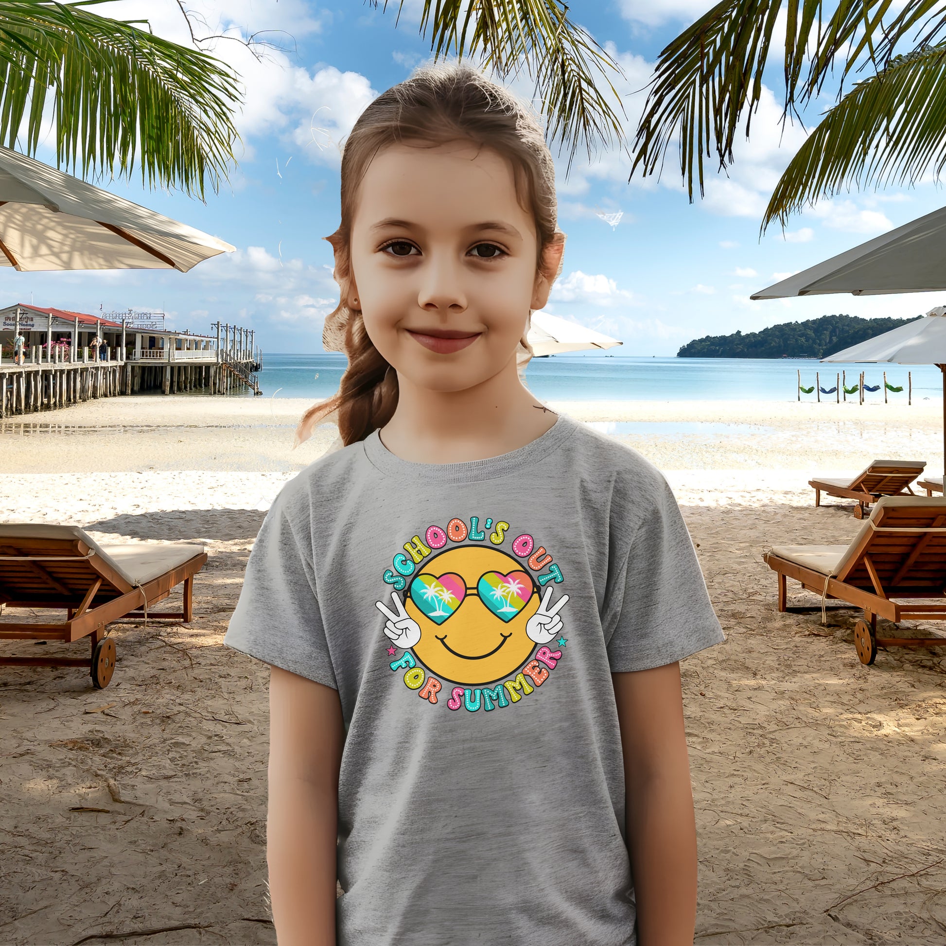 Child in grey t-shirt with a beach themed smiley face that says Schools Out for Summer