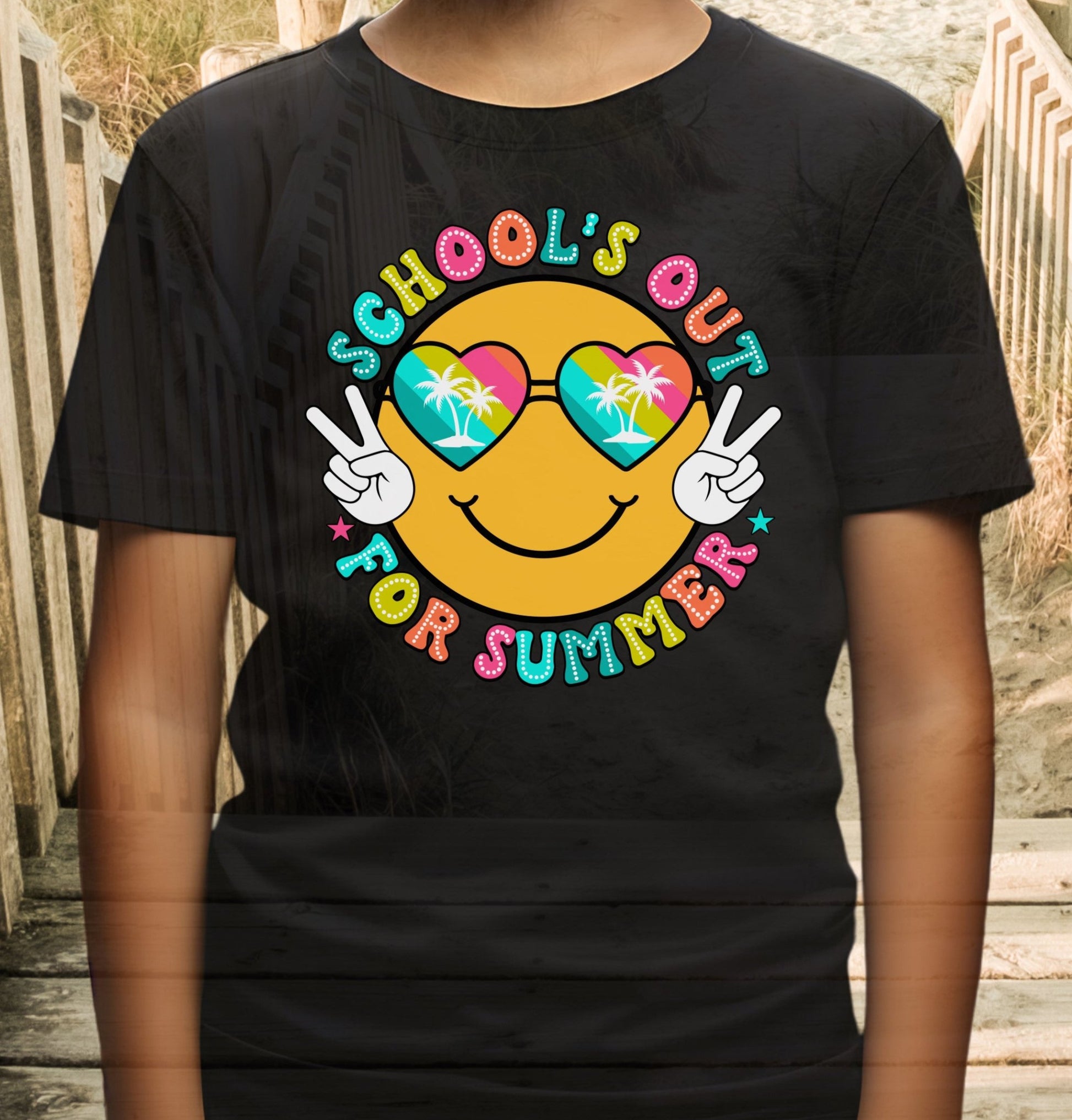 Child in black t-shirt with a beach themed smiley face that says Schools Out for Summer