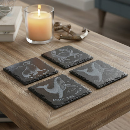 Set of four black slate coasters with sea animal illustrations and text.