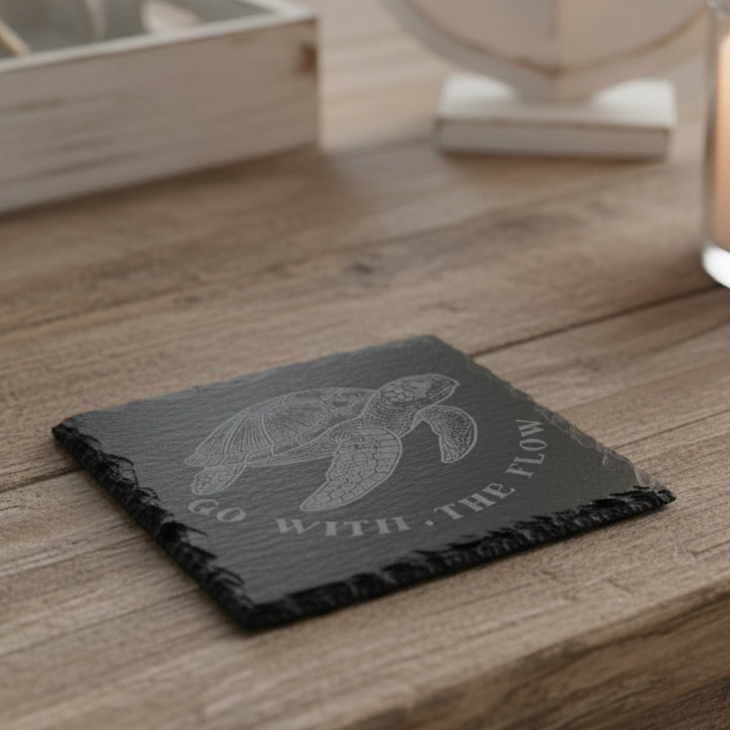 Decorative slate coaster with a engraved turtle design and text Go With the Flow.
