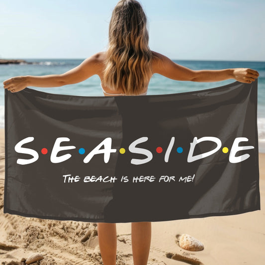 Black beach towel that says Seaside with colored dots in between and says The Beach is Here for Me