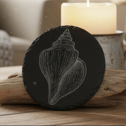 Black slate coaster a white shell design engraved.