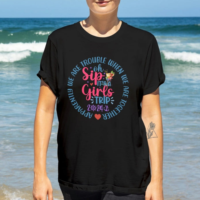 Woman wearing a personalized black t-shirt with colorful girls cruise t-shirt with text Oh Sip It's a Girl's Trip. 
