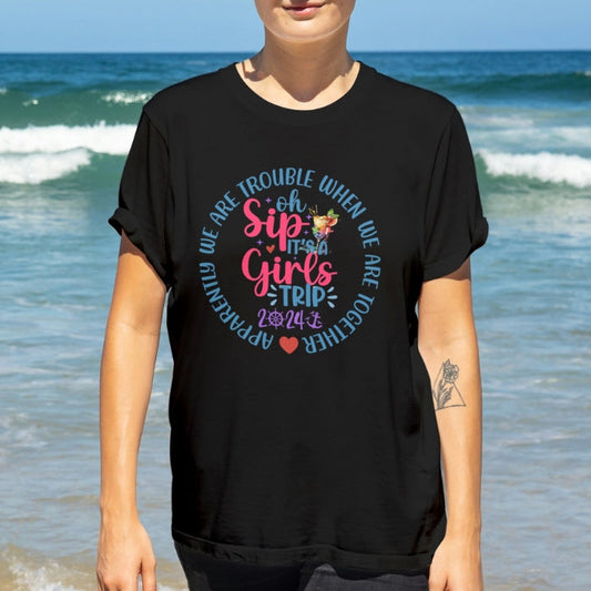 Woman wearing a personalized black t-shirt with colorful girls cruise t-shirt with text Oh Sip It's a Girl's Trip. 