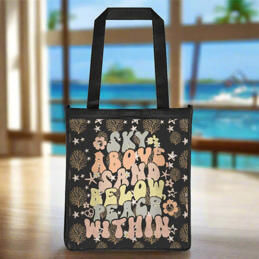 Black grocery bag with ocean foliage and starfish in tan colors with retro text that says sky above sand below peace within