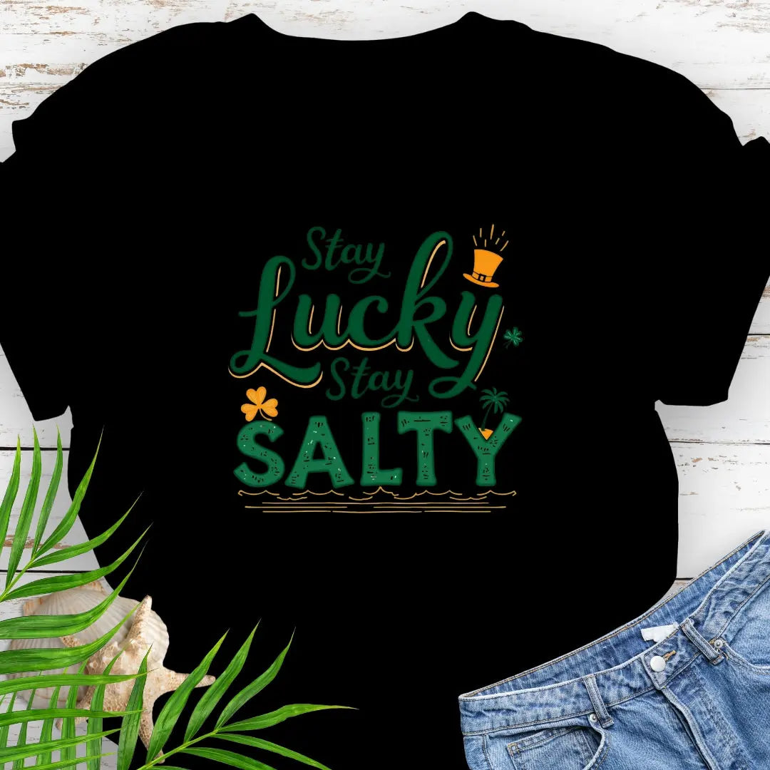Our Stay Lucky Stay Salty Black T-shirt with St. Patrick's Day and beach embellishments including shamrock, leprechaun hat, palm tree and ocean waves.
