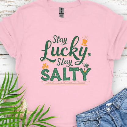 Our Stay Lucky Stay Salty Pink T-shirt with St. Patrick's Day and beach embellishments including shamrock, leprechaun hat, palm tree and ocean waves.