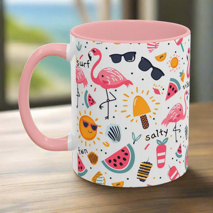 White beach-themed 11 oz coffee mug with pink inside and handle with colorful fun designs featuring flamingos, watermelon slices, sun, and popsicles. Perfect summer mug for beach lovers, tropical vibes, and sunny morning coffee.