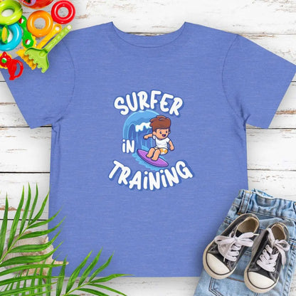 Surfer in Training Toddler's Heather Columbia Blue T-shirt featuring a child surfing.