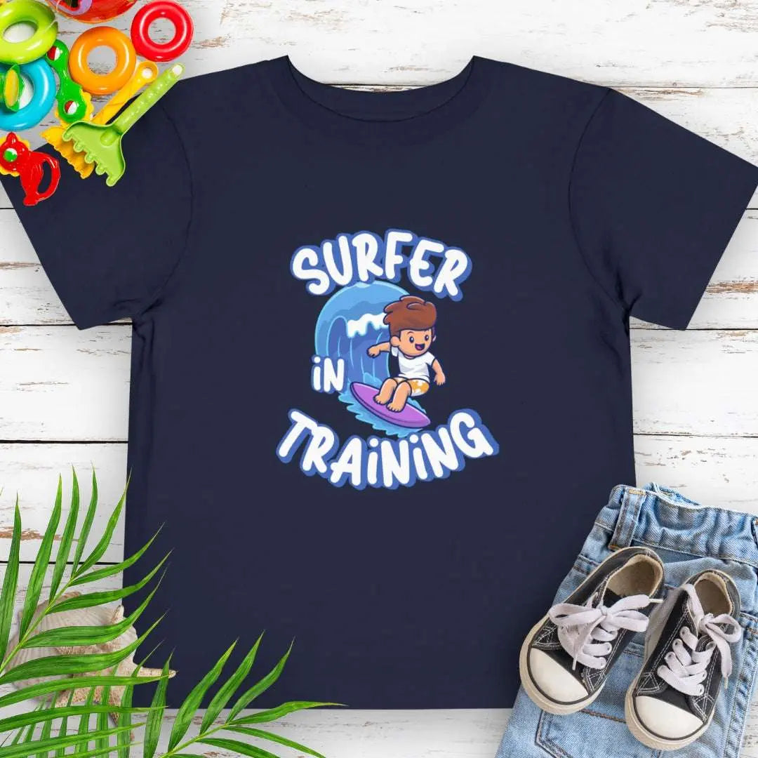 Surfer in Training Toddler's Navy T-shirt featuring a child surfing.