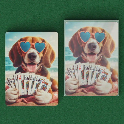 Playing cards with a beagle in heart glasses holding playing cards while laying on a beach and clear box