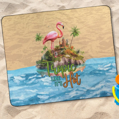 Outdoor beach blanket with sand on top half, water on bottom half with flamingo on island in middle with text Tropic like It's Hot.