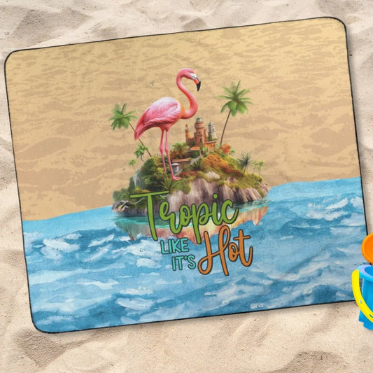 Outdoor beach blanket with sand on top half, water on bottom half with flamingo on island in middle with text Tropic like It's Hot.