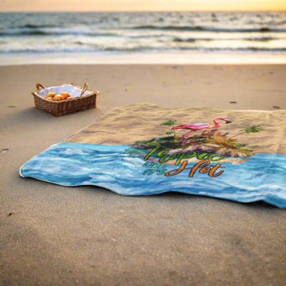 Outdoor beach blanket with sand on top half, water on bottom half with flamingo on island in middle with text Tropic like It's Hot.
